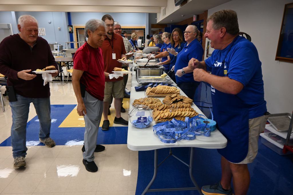 Commercial Bank Employees serve USd 503 employees lunch and Ray Jacquinot hands them tickets for a drawing.