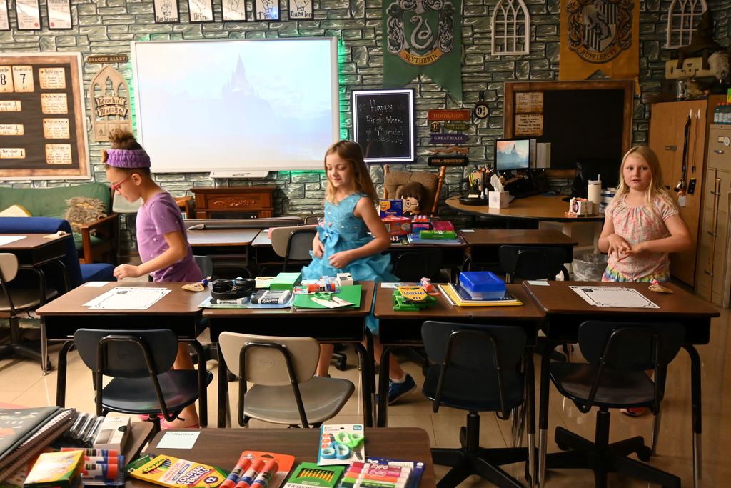 Three ,little girls see where their desks are at Gutridge and who their classmates will be in Mr. Holmes class.