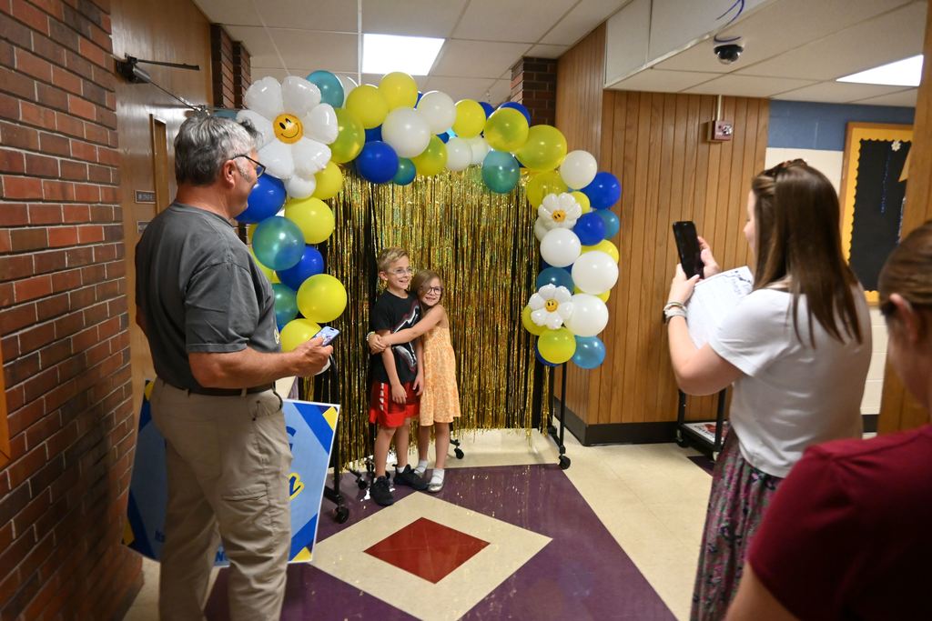 A parent takes her kids' picture.