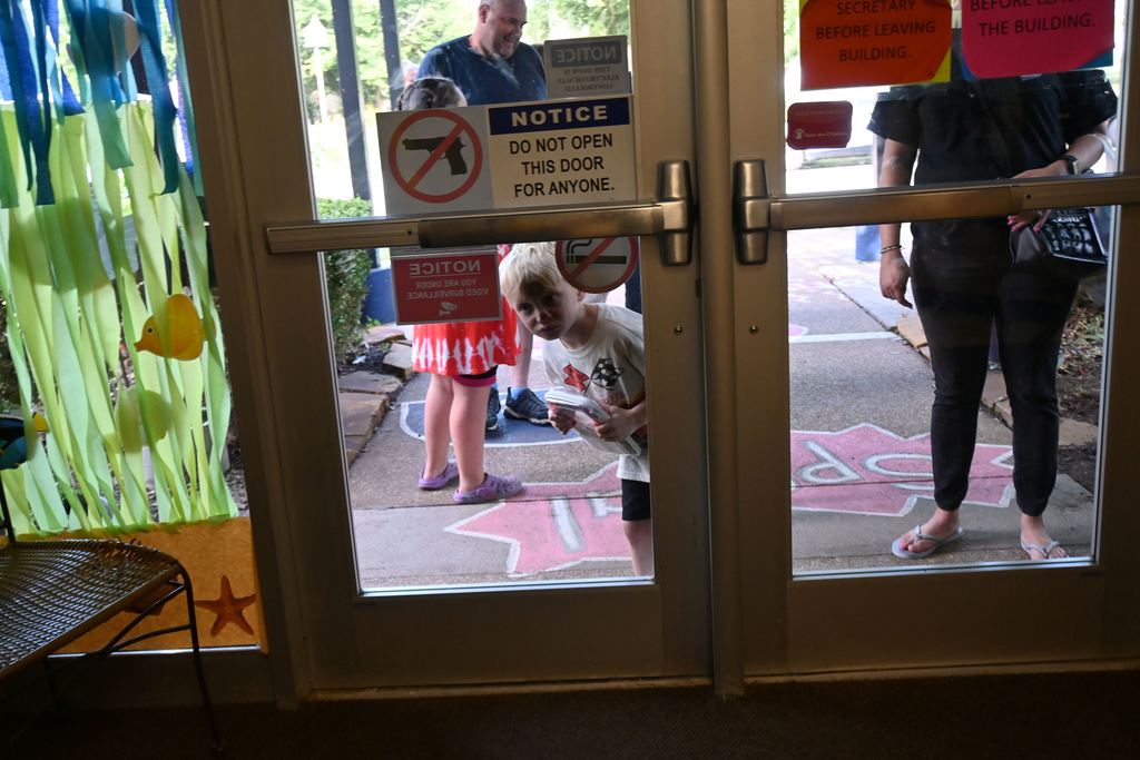 A boy peeks through the doors as he waits for them to be opened at Lincoln for the Sneak Peek.