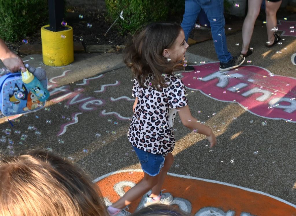A girl runs through bubbles/