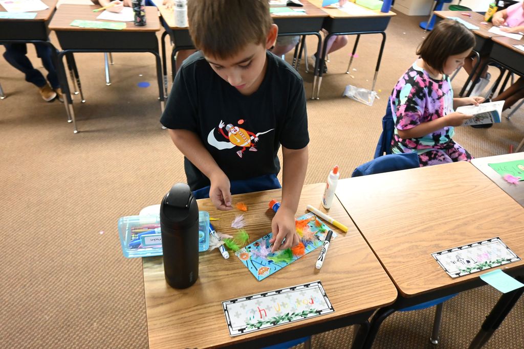 A boy decorates his name plate.