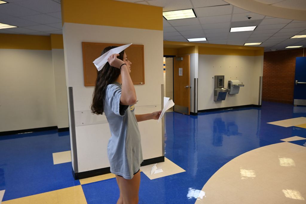 A girl prepares to throw one of her teams planes.