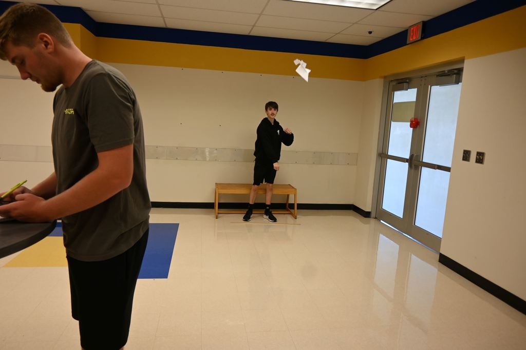 A teammate launches a paper airplane