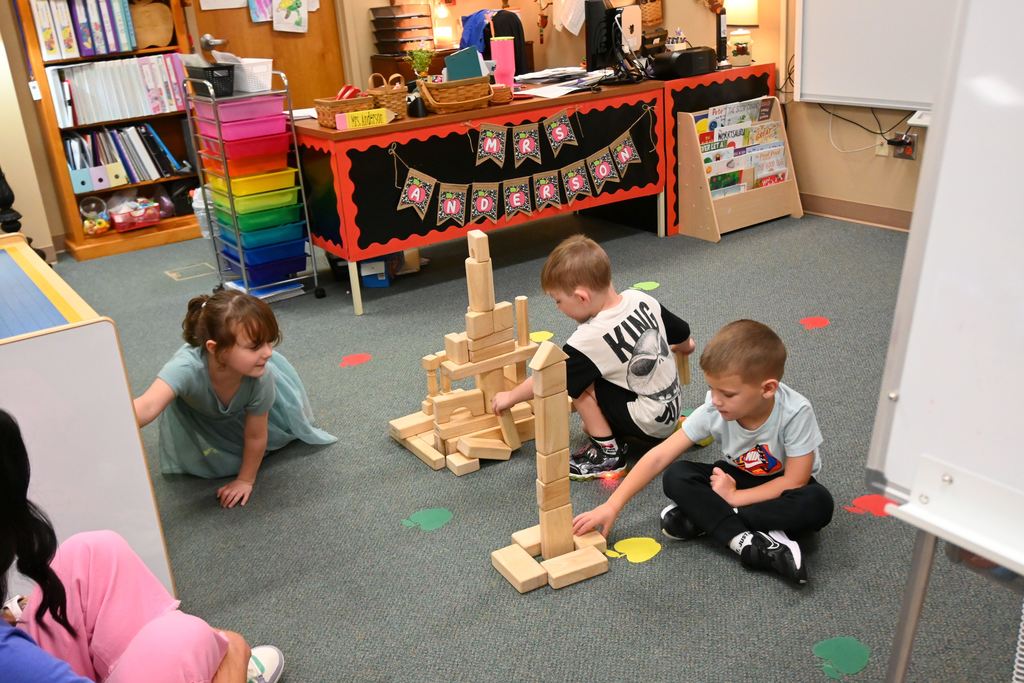 Children build with wooden blocks.