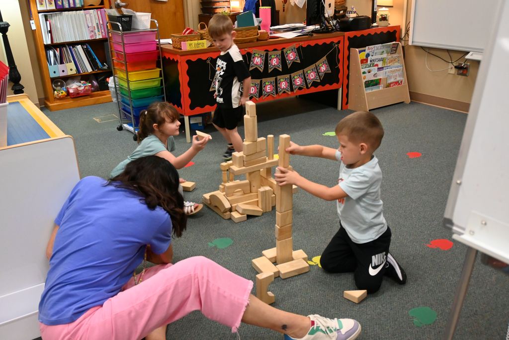 Children build towers and buildings with wooden blocks.