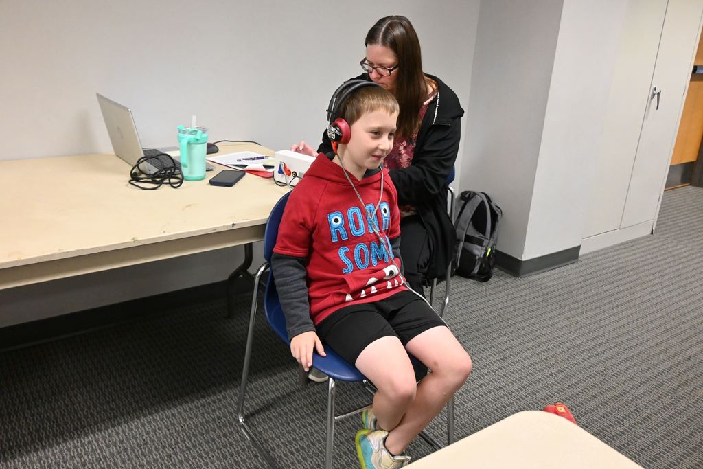 A boy prepares to take his hearing test.