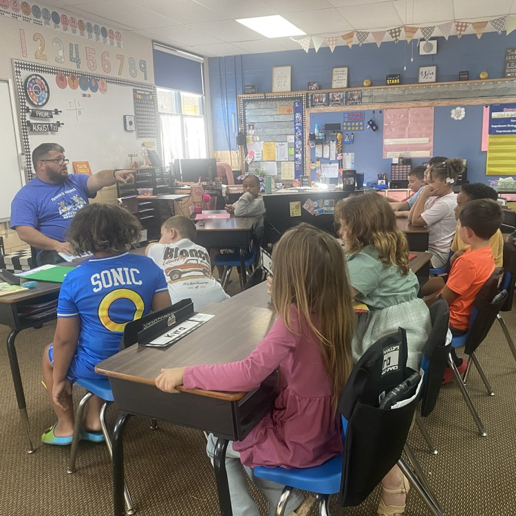 principal reading to a class of students