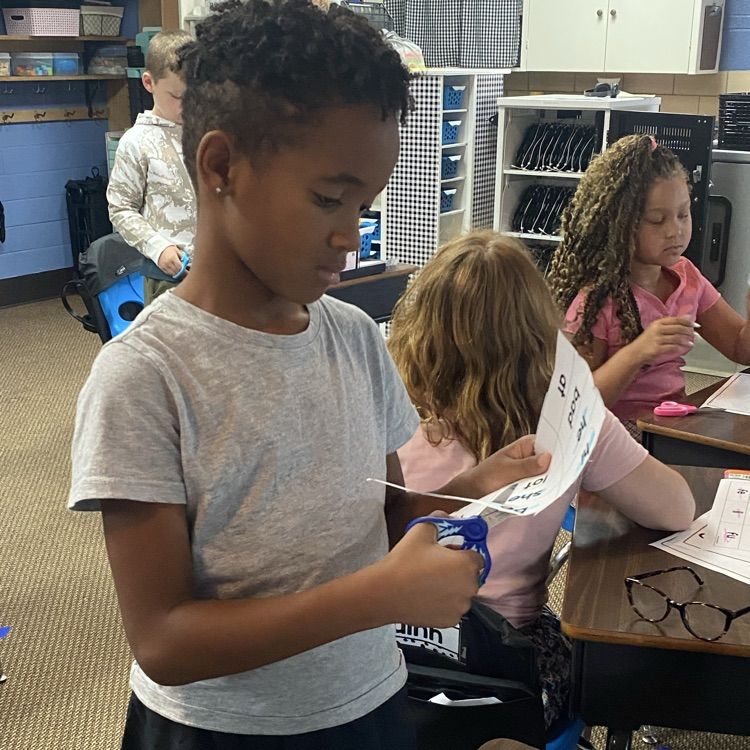 student cutting out slips of paper to sort syllable types