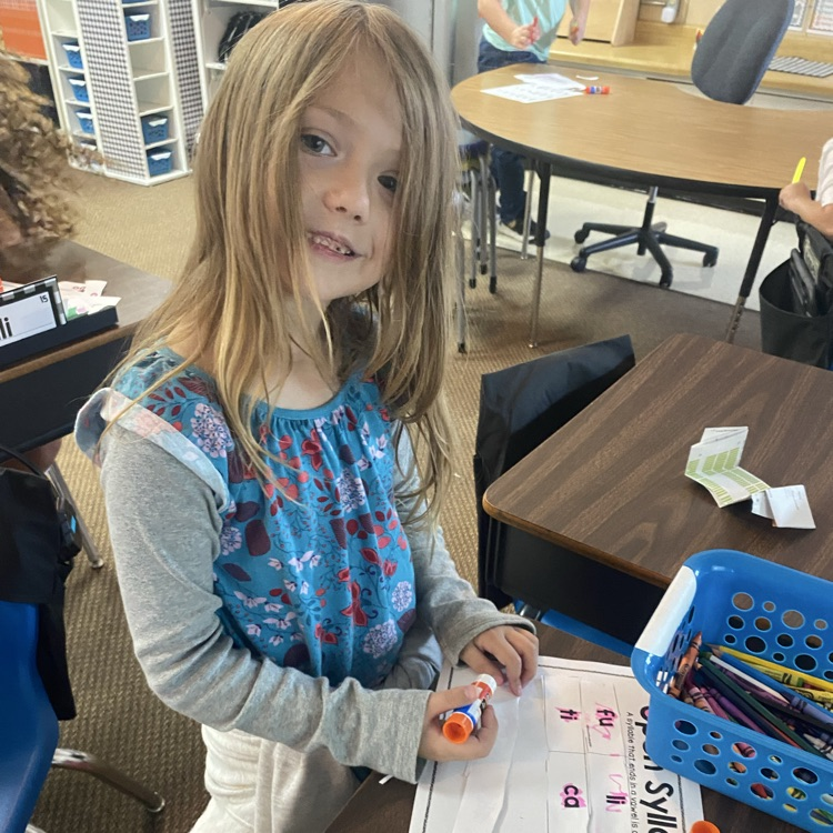 student cutting out slips of paper to sort syllable types