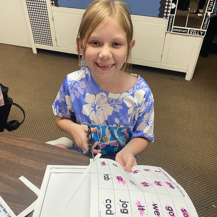 student cutting out slips of paper to sort syllable types