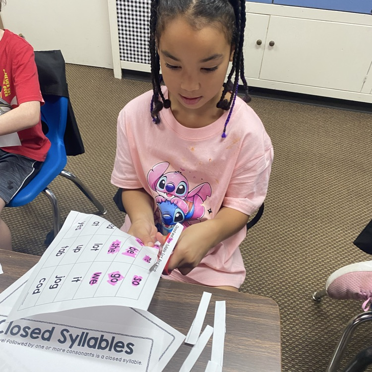 student cutting out slips of paper to sort syllable types