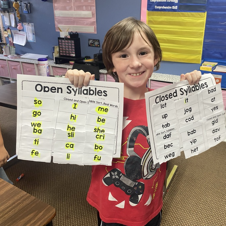student holding up completed syllable sort