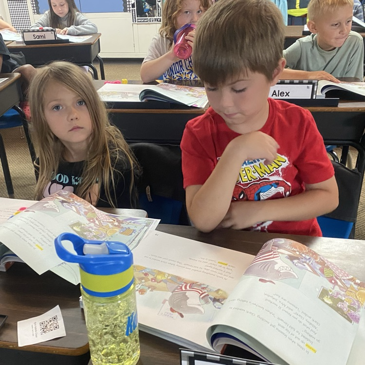 students reading from a textbook