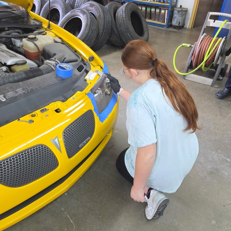 A student works on the headlights.