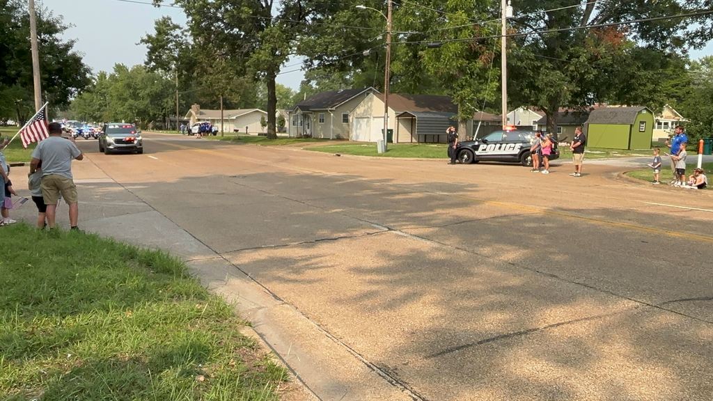 Small groups of USD 503 family gather along 32nd street to honor fallen officer Hunter Simoncic as his funeral procession goes by.