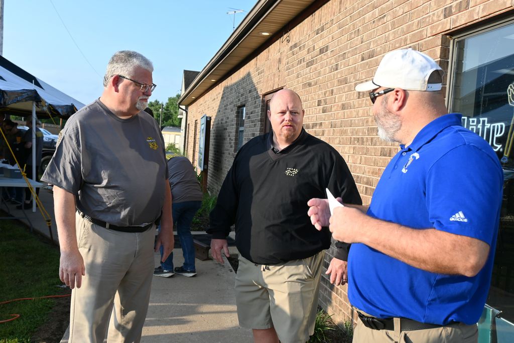 Chief Spinks and Lt. Jason Ludwig visit with golf coach Paul Duroni.