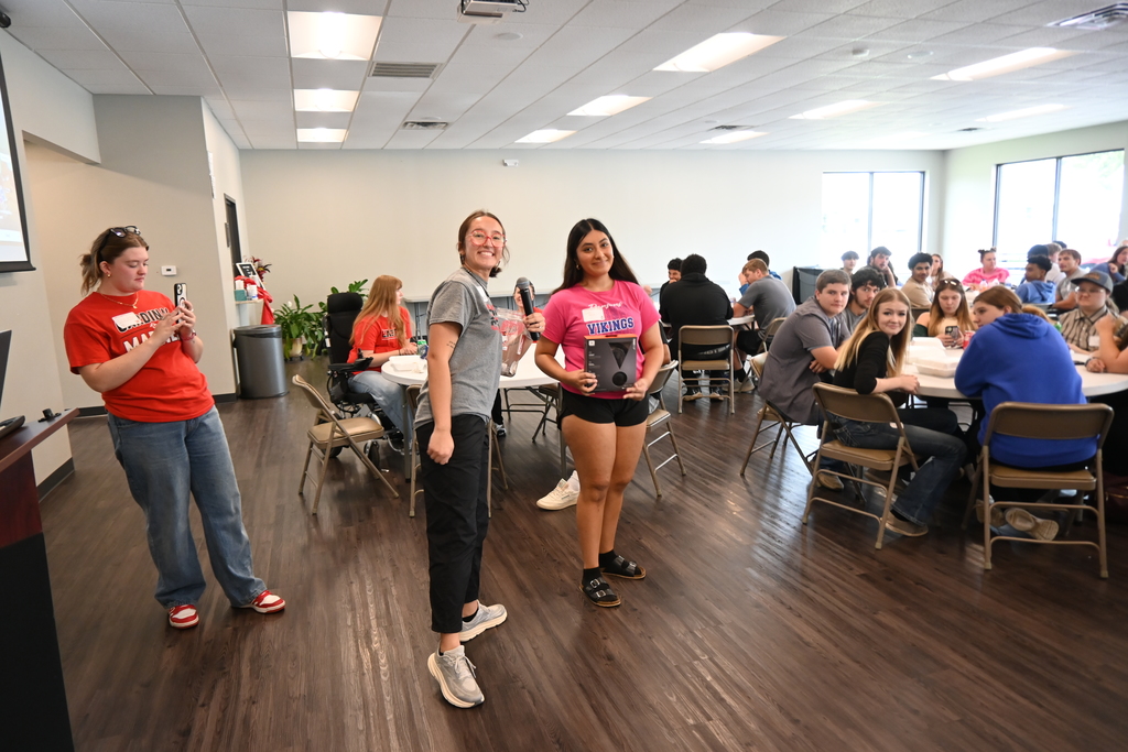 A student stands wit Mia Howard after winning a set of headphones.