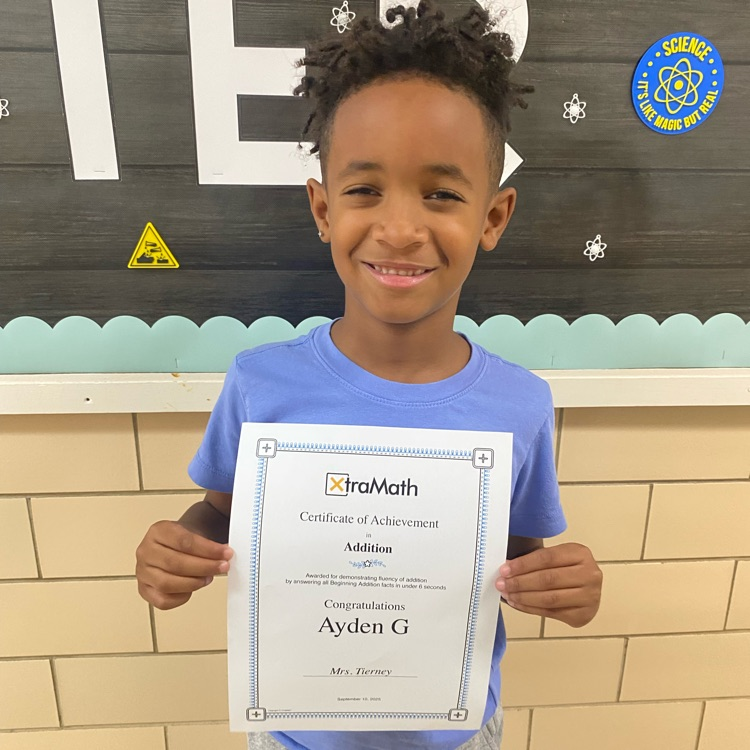 student holding a certificate of completion of xtra math