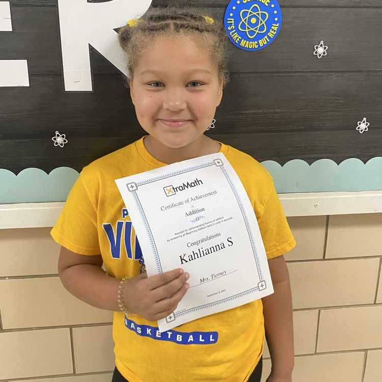 student holding a certificate of completion of xtra math