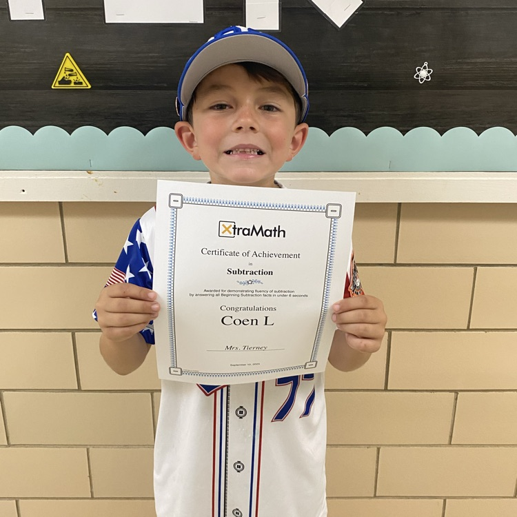 student holding a certificate of completion of xtra math
