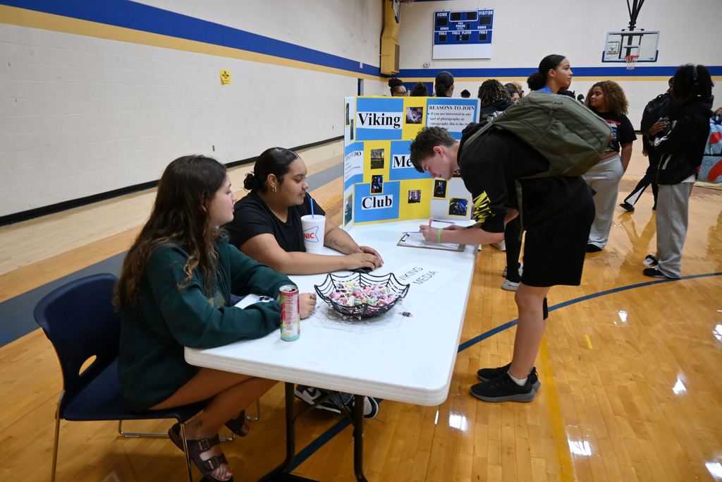 A student signs up for Viking Media Club.