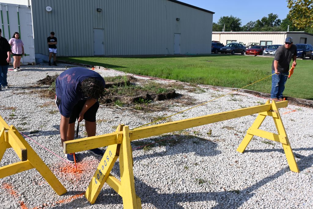 Mr. Giplin and a student measure for  the foundation of the greenhouse.