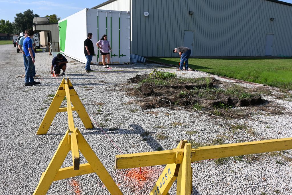 Mr. Gilpin and a student measure for the foundation of the greenhouse.