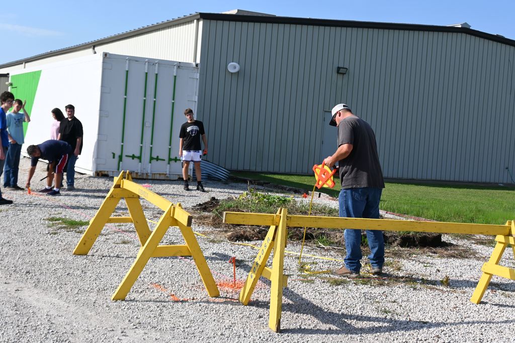 Mr. Gilpin and a student measure for the foundation of the greenhouse.