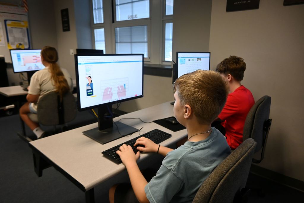 Students type out words that appear on the screen.