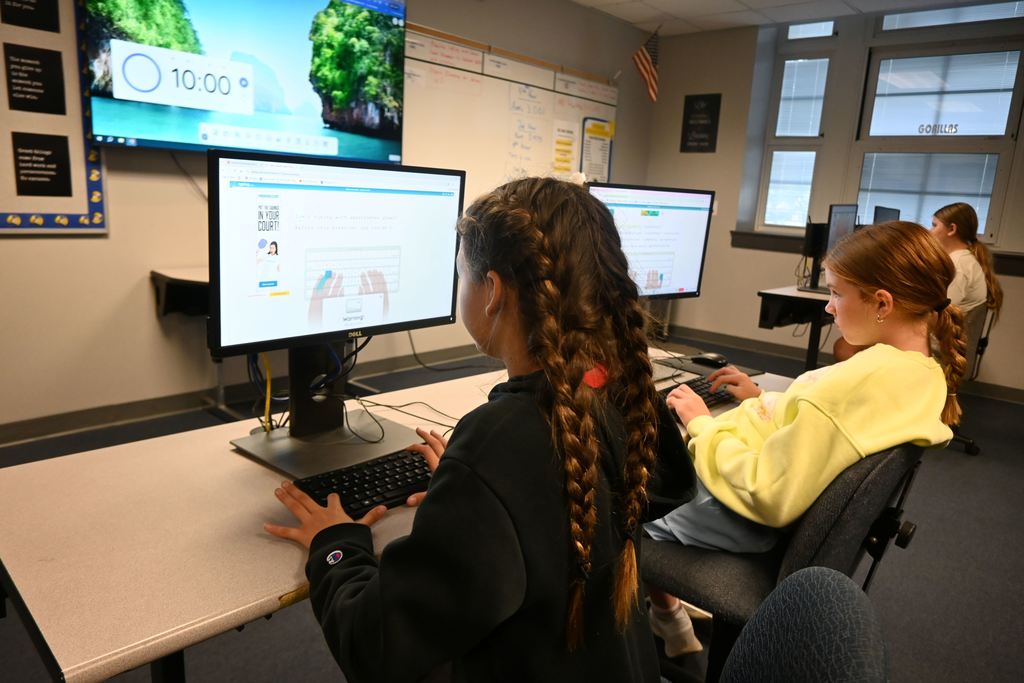 Students type out words that appear on the screen.