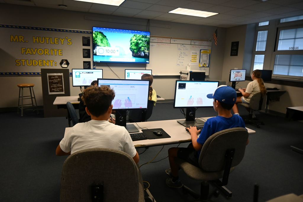 Students type out words that appear on the screen.