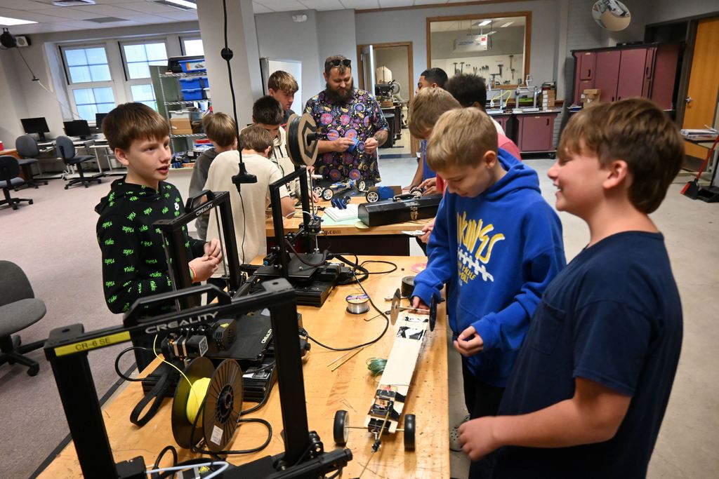 sTUDENTS WORK IN THE LAB MAKE ADJUSTMENTS AND REPAIRS TO THEIR MOUSE TRAP CARS.