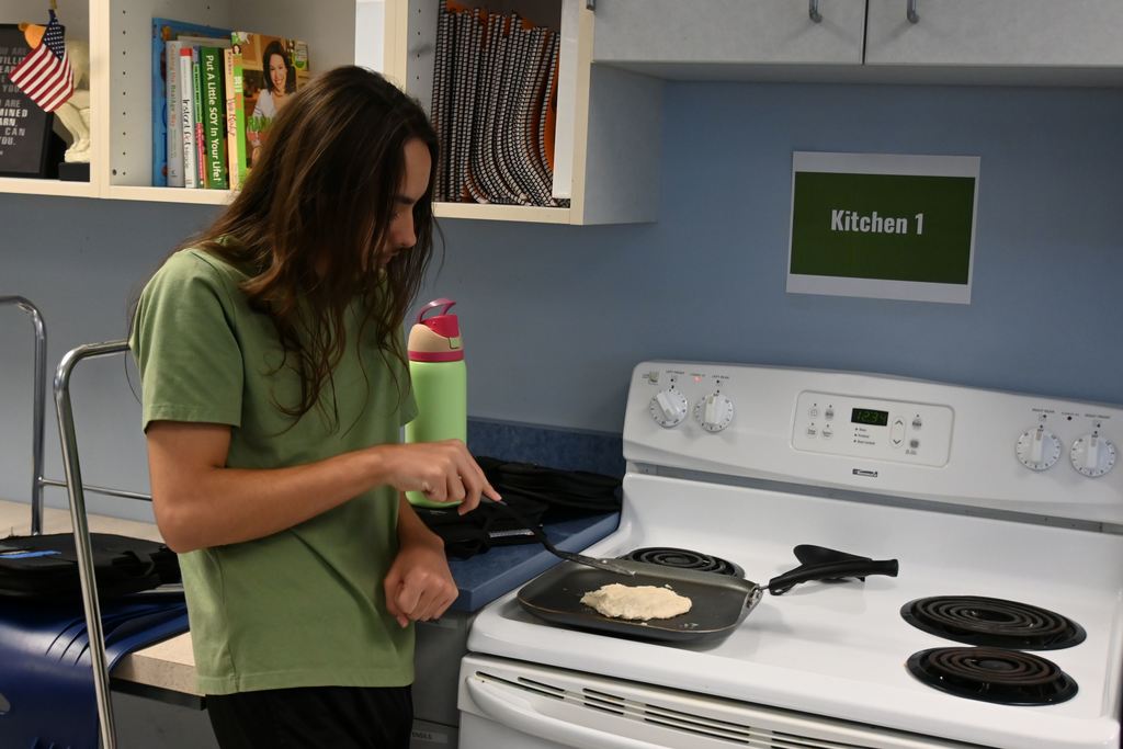A young man cooks his pita on a griddle.
