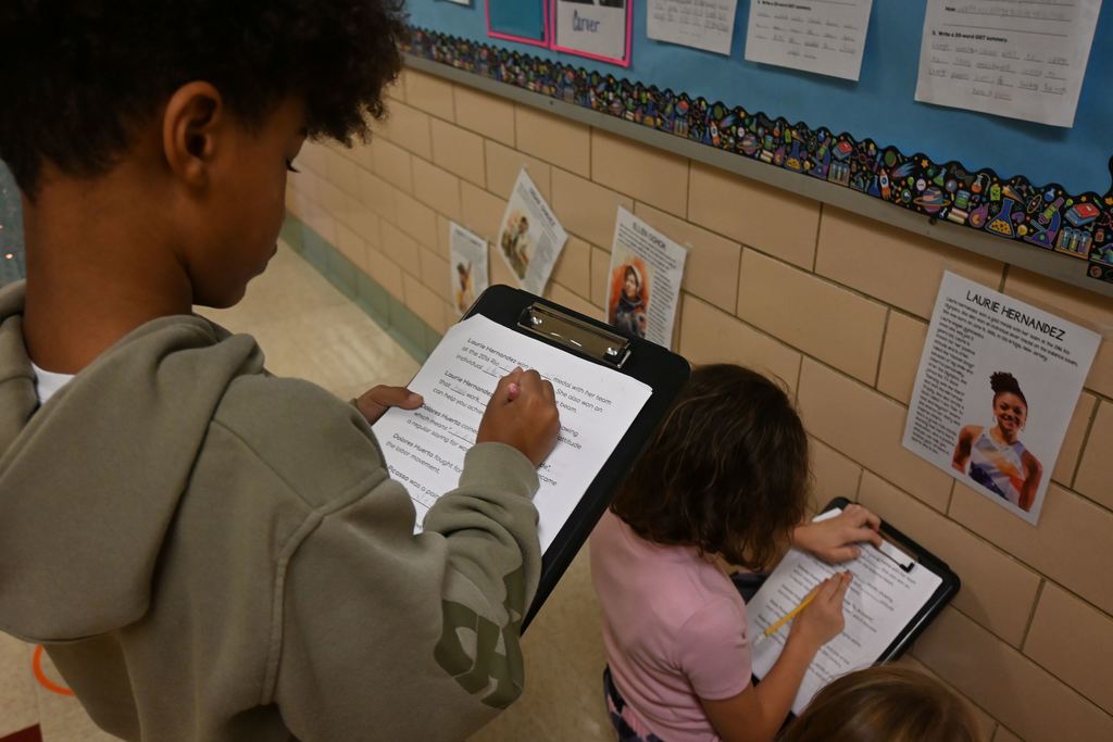 Two students search for information on the profiles of famous Hispanics hung in the hall.