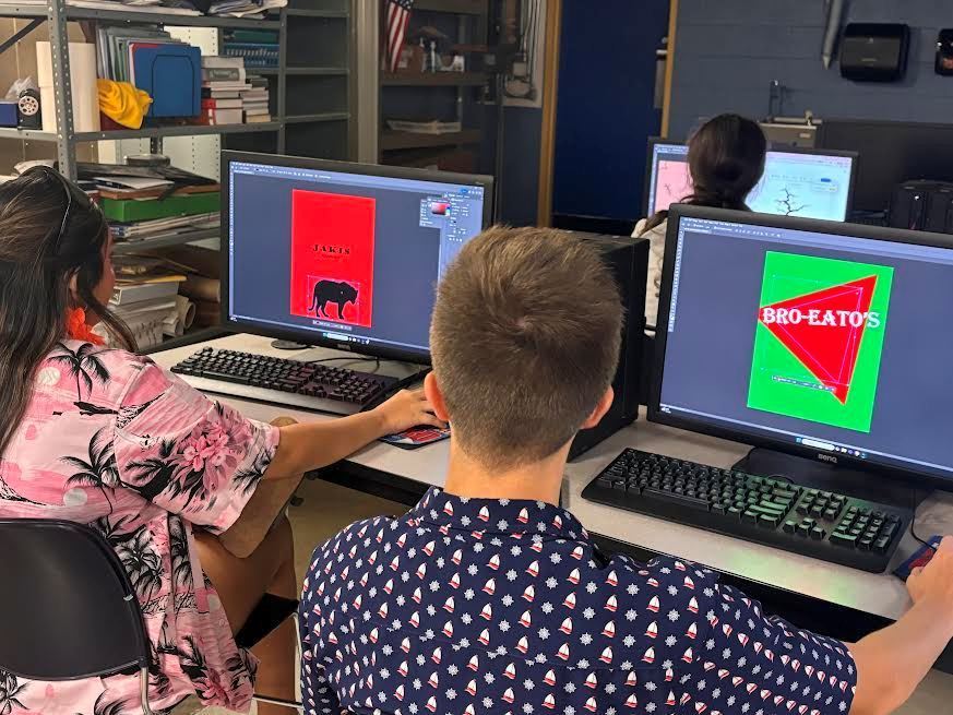 A girl and a boy work on their chip bag designs.