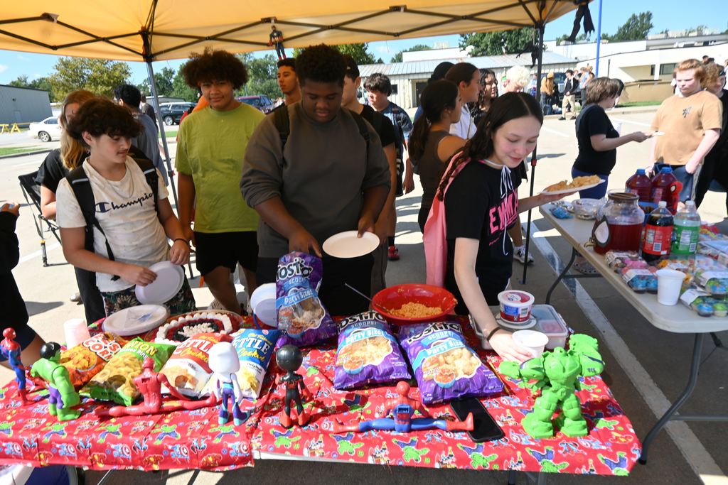 Students grab food at Superhero tent.