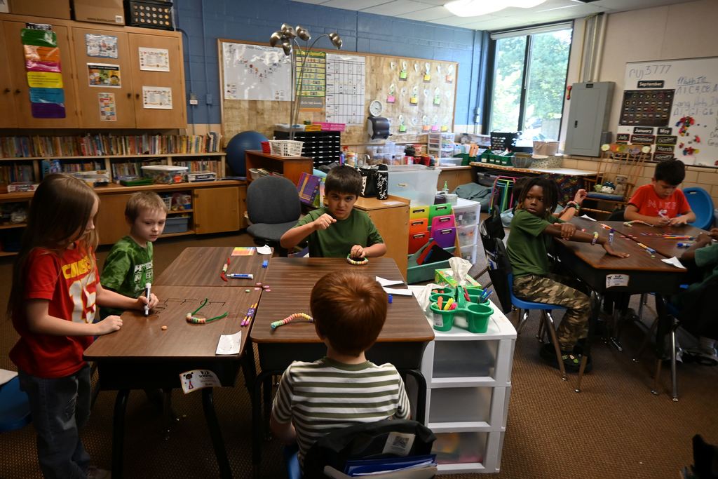 Students make place value bracelets.