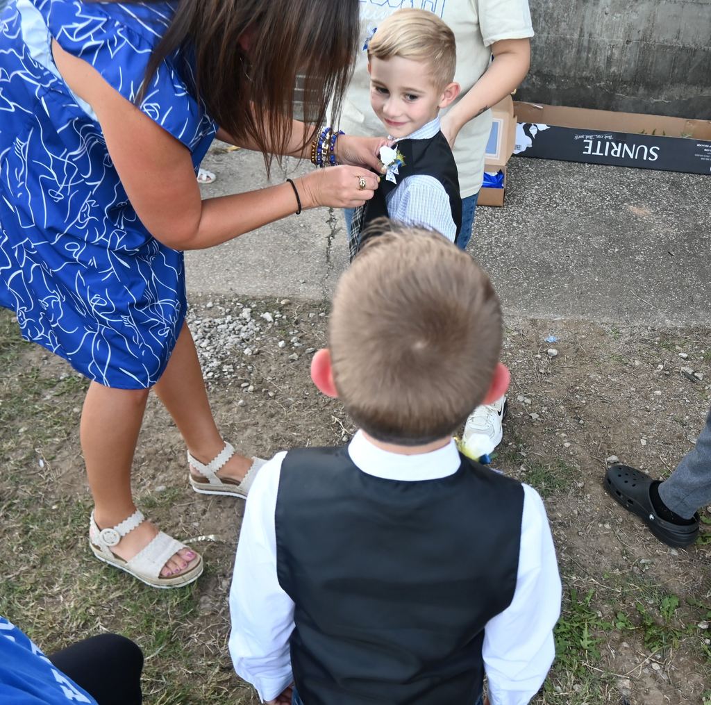 Kylie Lucas pins a boutonnaire on a little boy.