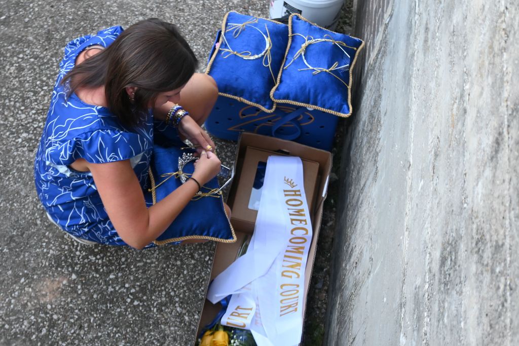 Kylie Lucas ties the crowns to the pillows in preparation for the coronation.
