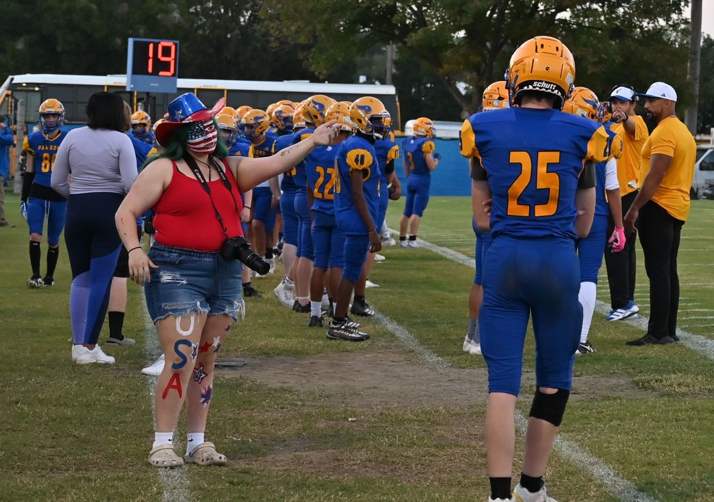 A student is dressed in red, white and blue.and has painted face and legs.