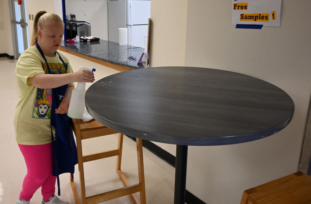 A student cleans the table where taste testing was done.