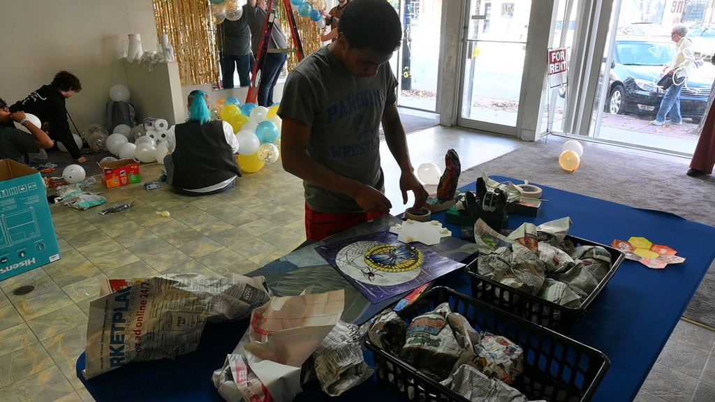 A student prepares art for showing.