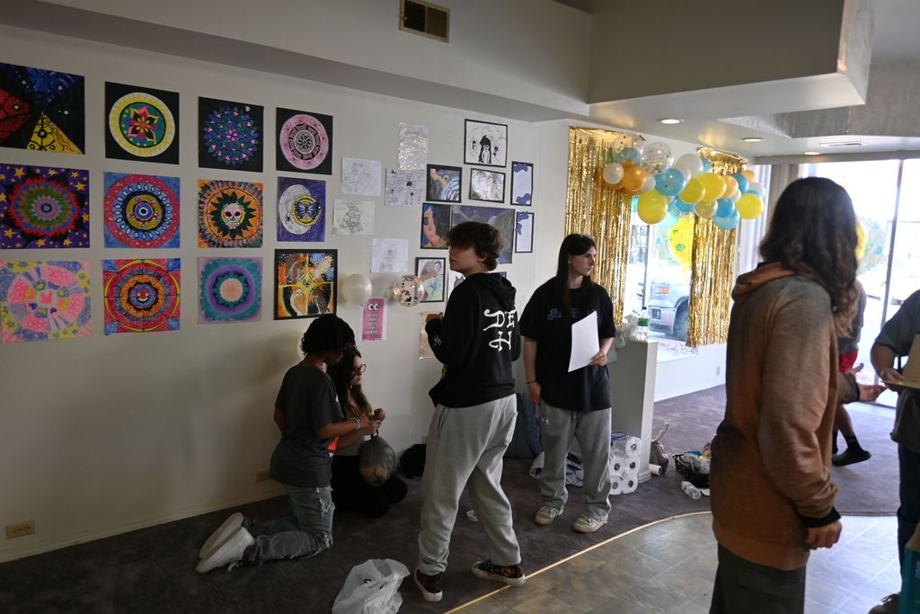Students blow up ballons and hang art.