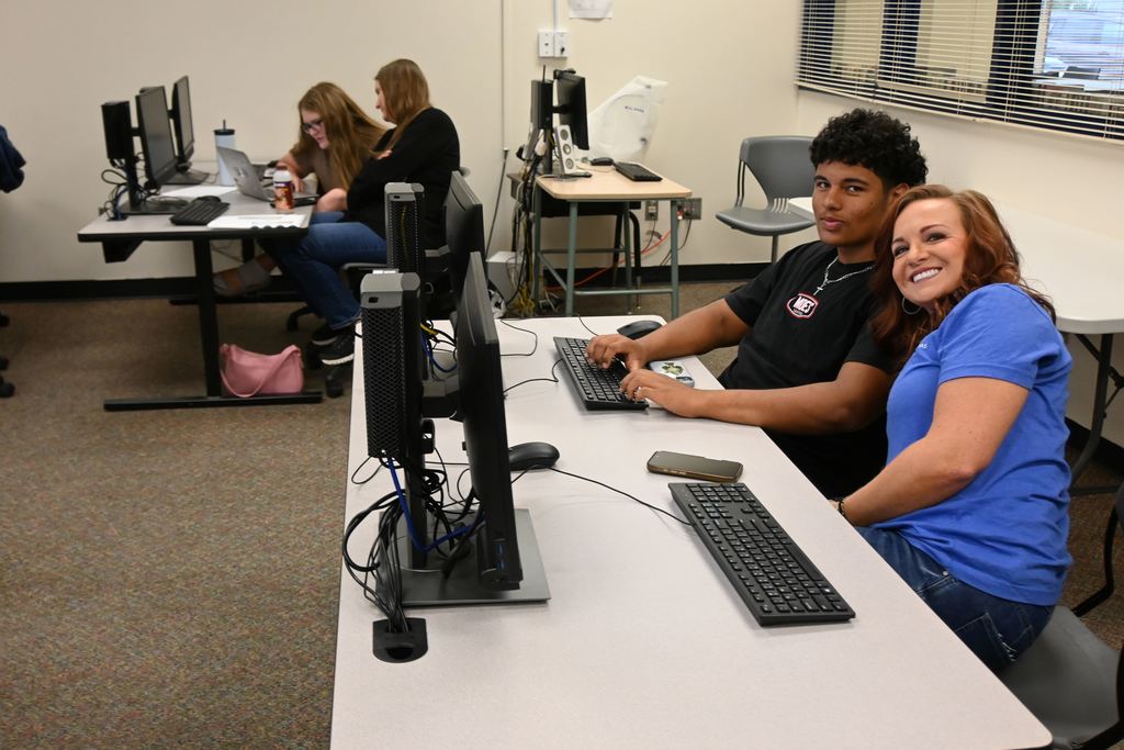 Board member Kala Green helps a student with his college application.