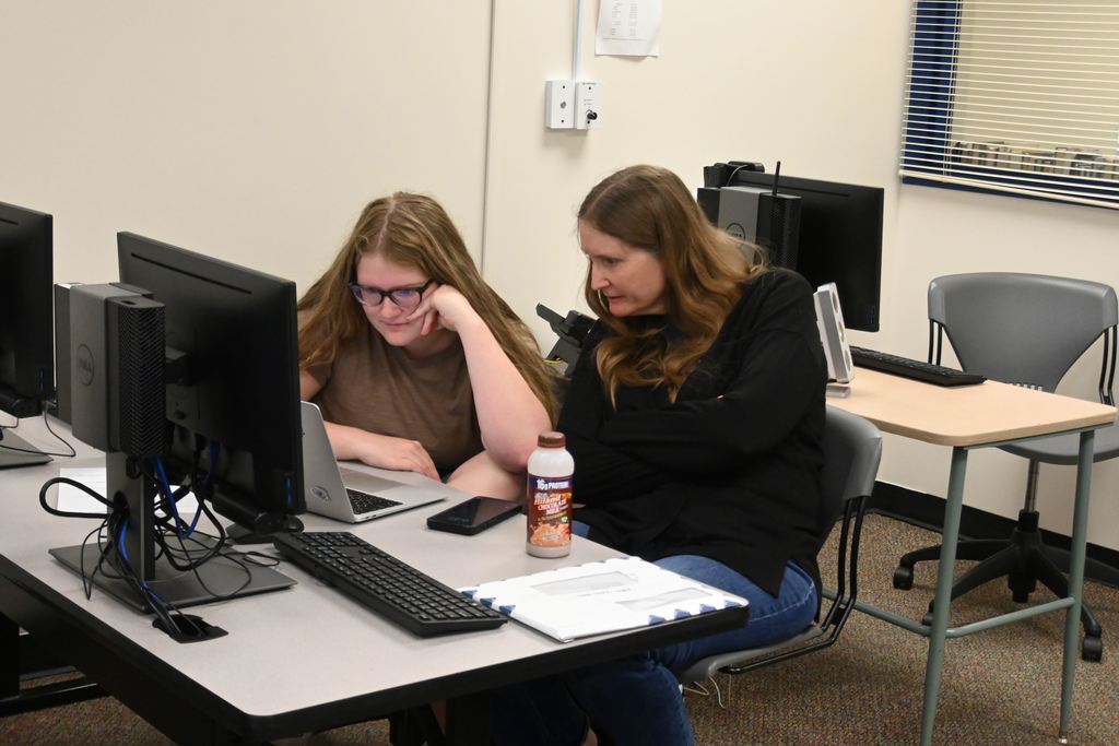 A mother helps her daughter with applications.