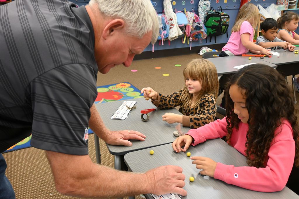 Mr. Gary helps two students with magnets.