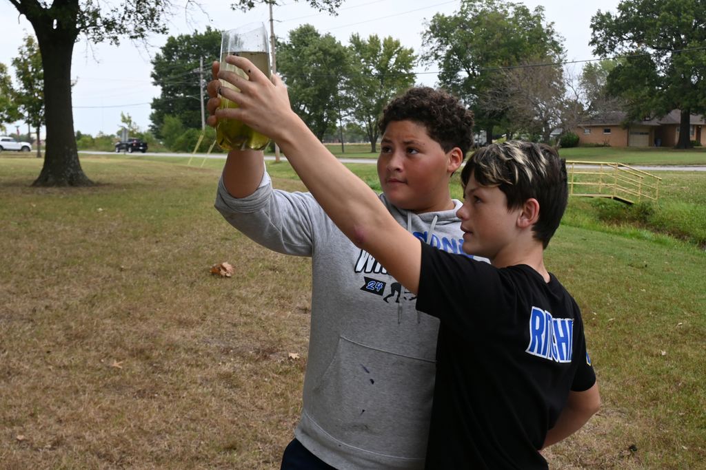 Two boys check out the multiple minnows they caught.