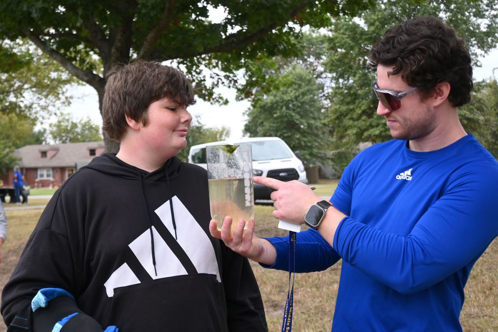 Mr. Ozier talks to a student about what he has collected and what he still needs for his mini ecosystem.