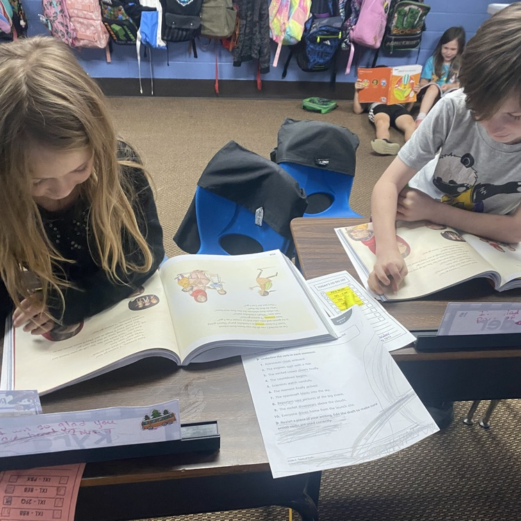 students reading from their textbook